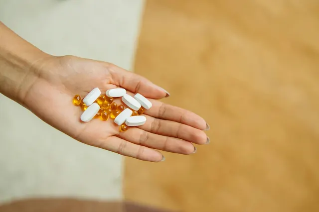 A friendly and professional nutritionist smiling while holding a selection of vitamin supplements, representing VitKenDev's trusted and client-focused approach to health